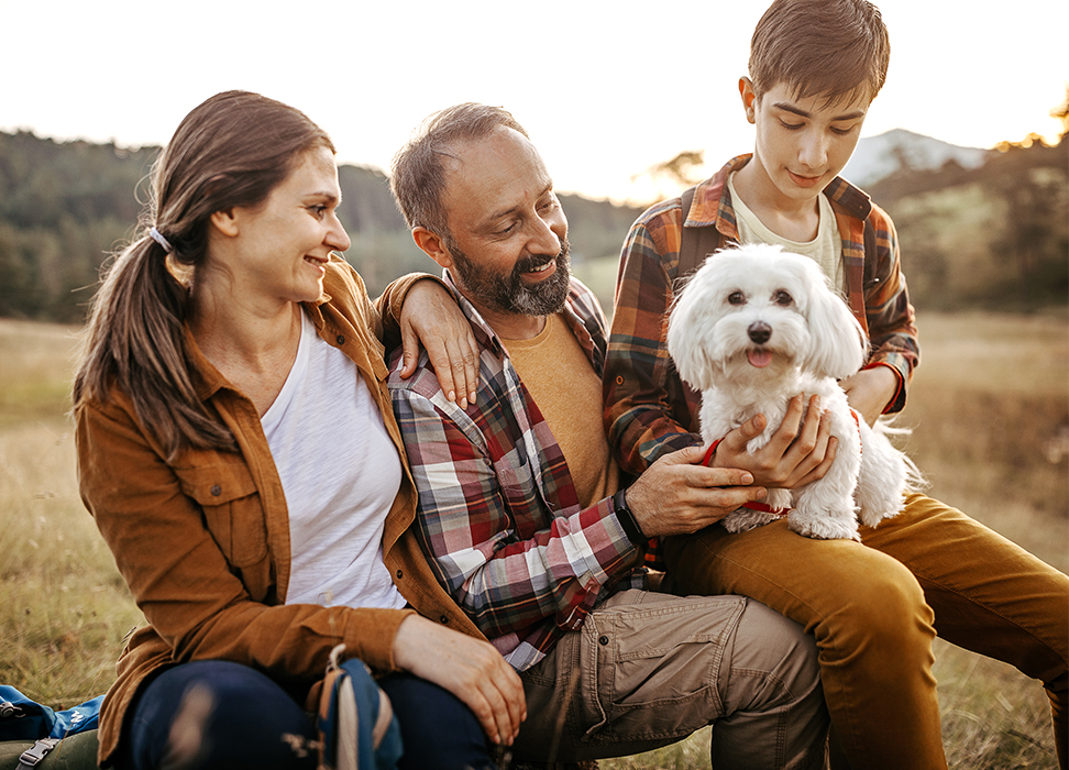 Happy family with their dog in a field