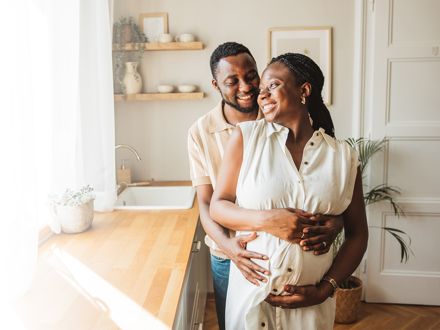 Smiling pregnant couple standing in the kitchen